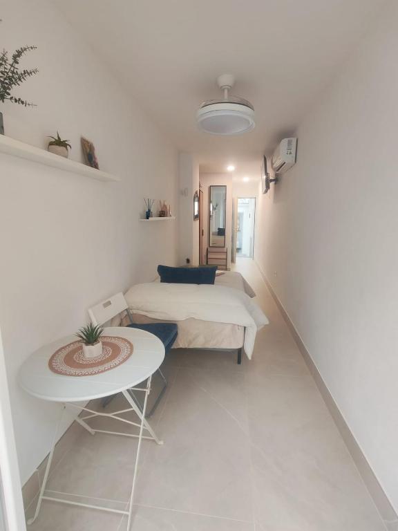 a white room with a bed and a table at Ancha 4 en pleno centro in Sanlúcar de Barrameda