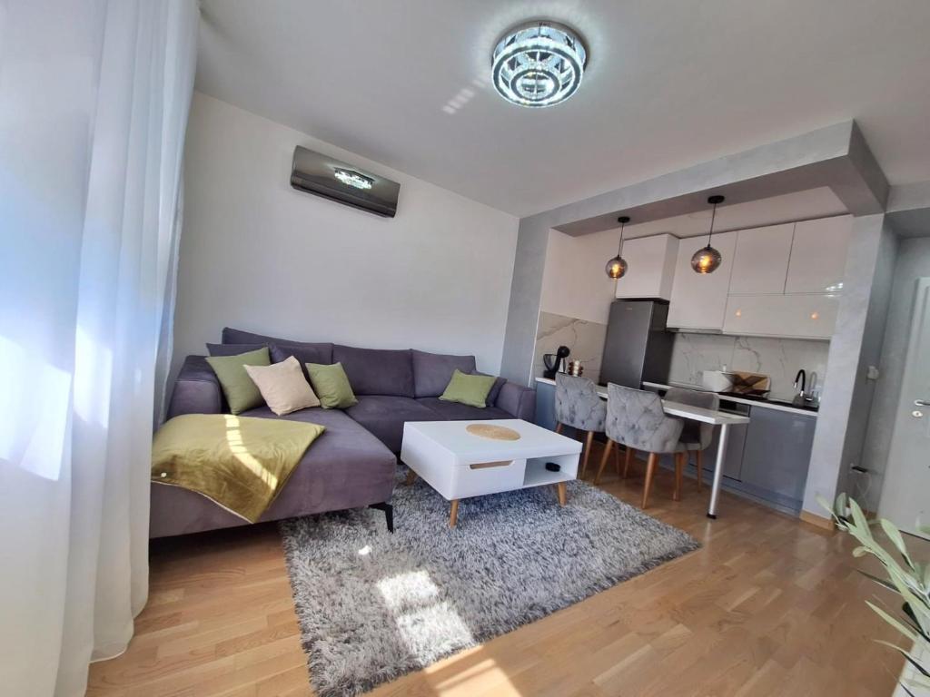 a living room with a couch and a table at Olea relax apartman in Brčko
