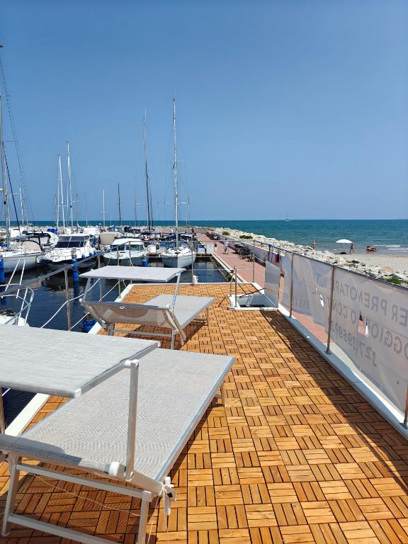 a dock with tables and chairs and boats in the water at House Boat Cervia in Cervia