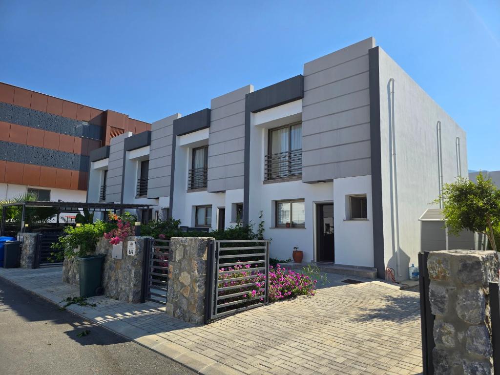 a white building with a fence in front of it at Villa West Park, Kyrenia in Kyrenia