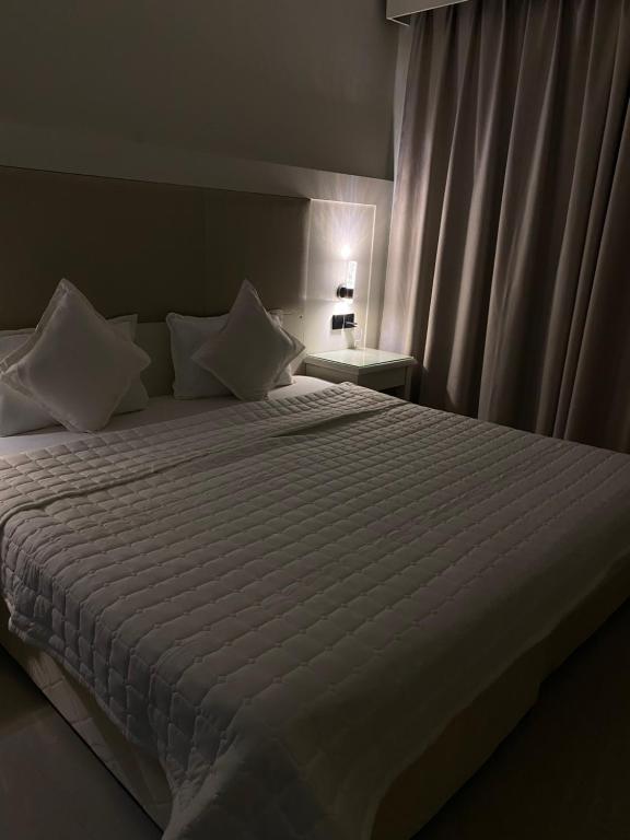 a bedroom with a large bed with white sheets and pillows at شقه in Ar Rass