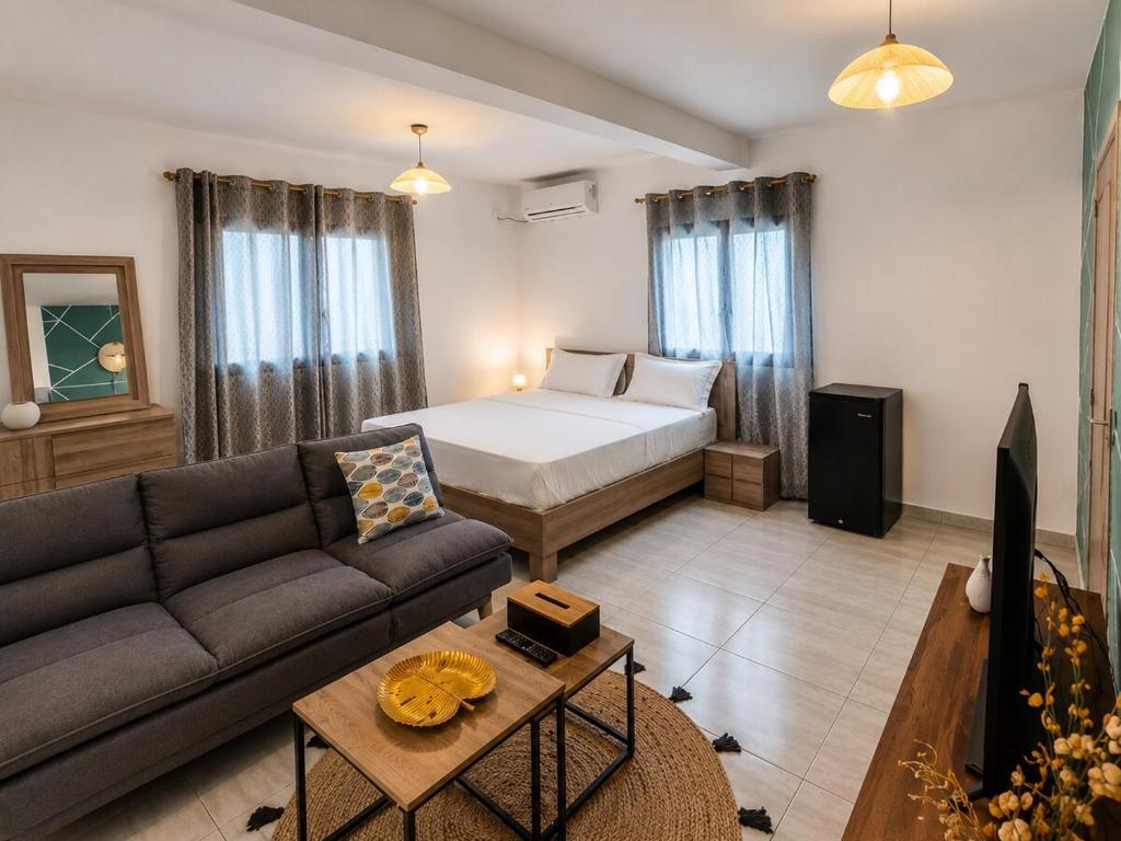 a living room with a bed and a couch at Le Cocon de Tahiti Plage in Sada