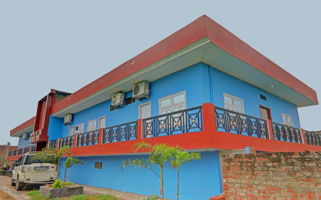 a blue building with a red balcony at Super Hotel O Surya Inn in Varanasi
