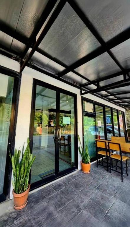 a patio with glass doors and potted plants at Jonah Hotel in Chiang Mai