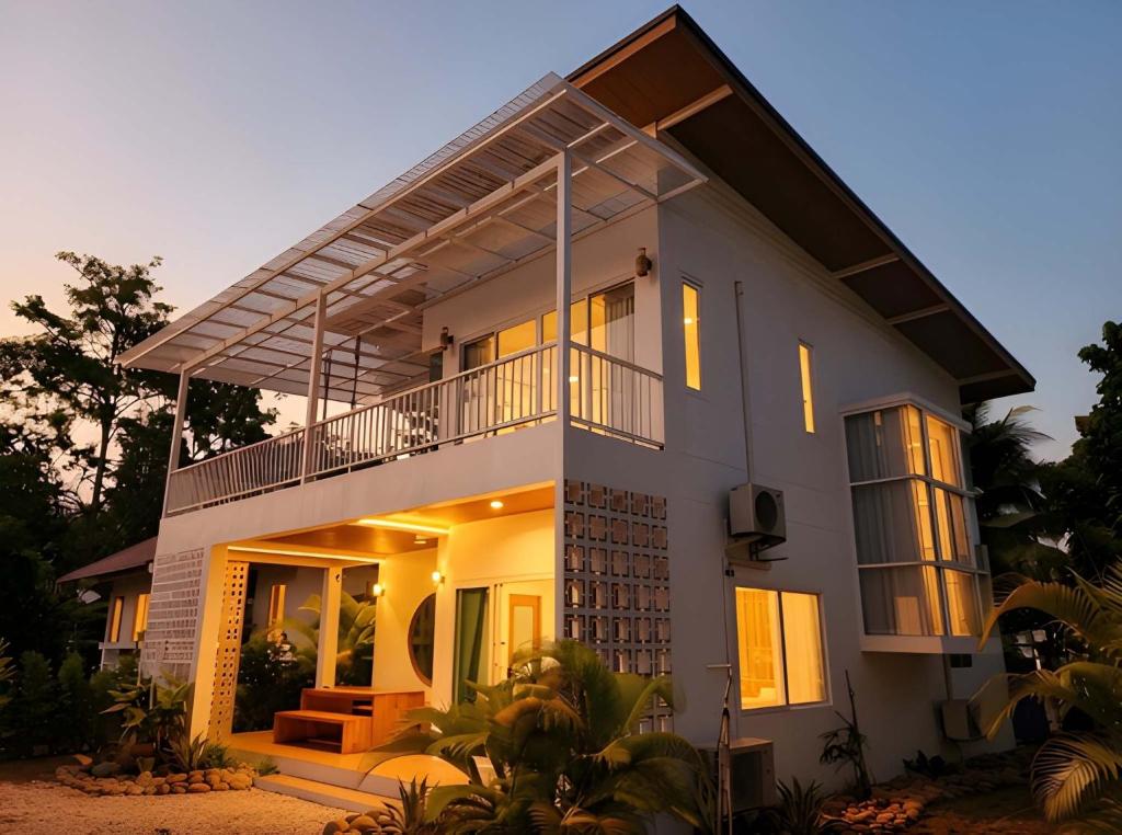 a large white house with its lights on at Casa Amara in Ko Phangan