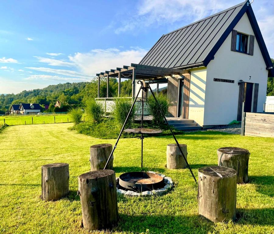 a house with a fire pit in the yard at KORBIELOVKA domek z sauną in Korbielów