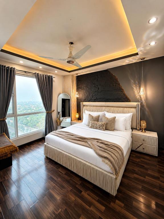 a bedroom with a large bed and a large window at ELYSIUM TOWER- One Bedroom Luxury Apartment With Balcony & City View OPP Centaurus Mall Islamabad in Islamabad