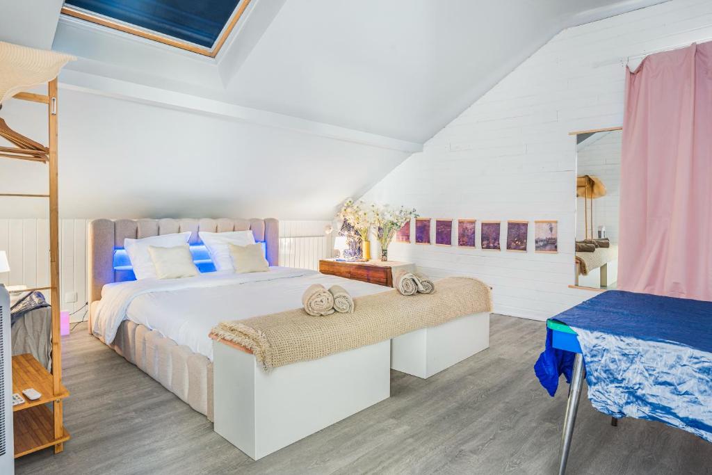 a white bedroom with a bed and a table at Monet Garden Retreat in Giverny
