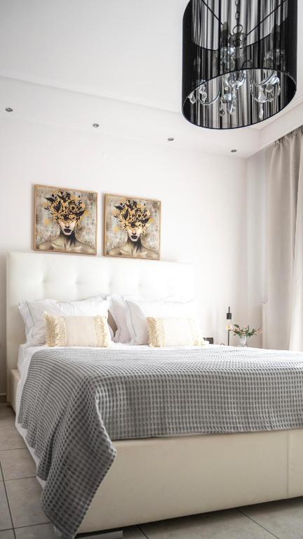 a bedroom with a white bed with a chandelier at Villa Twins in Myrina