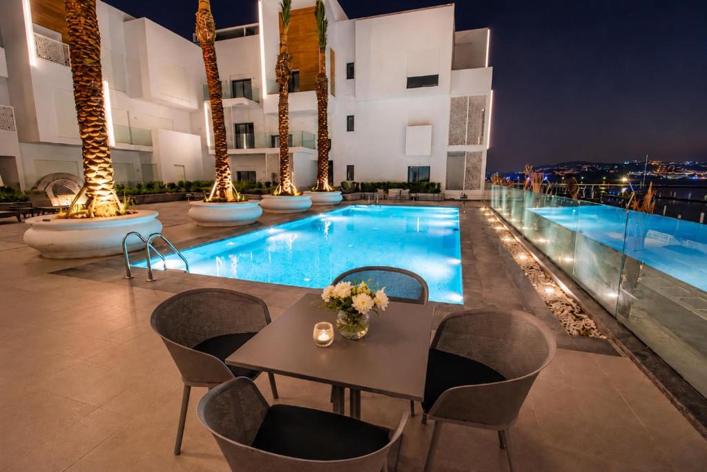 a hotel patio with a table and chairs and a pool at Royal Rif Tanger Marina Bay in Tangier