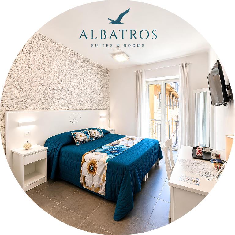 a bedroom with a bed with a blue comforter at ALBATROS Suites&Rooms in Naples
