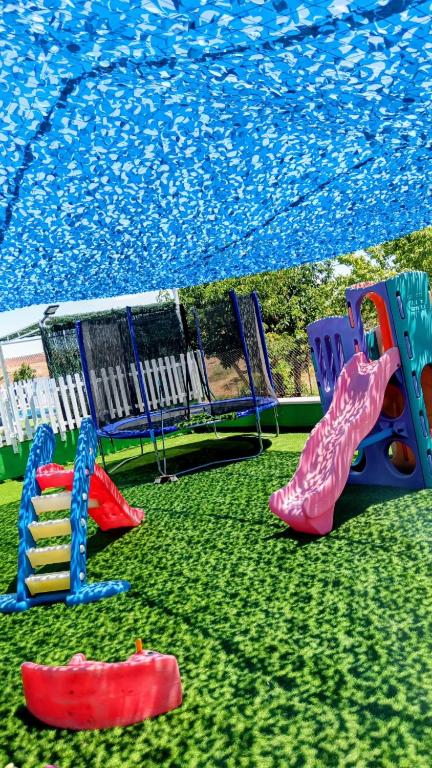 a group of playground equipment on the grass at Casas Rurales Alhambra - Lagunas de Ruidera - ESPECIAL GRUPOS in Alhambra