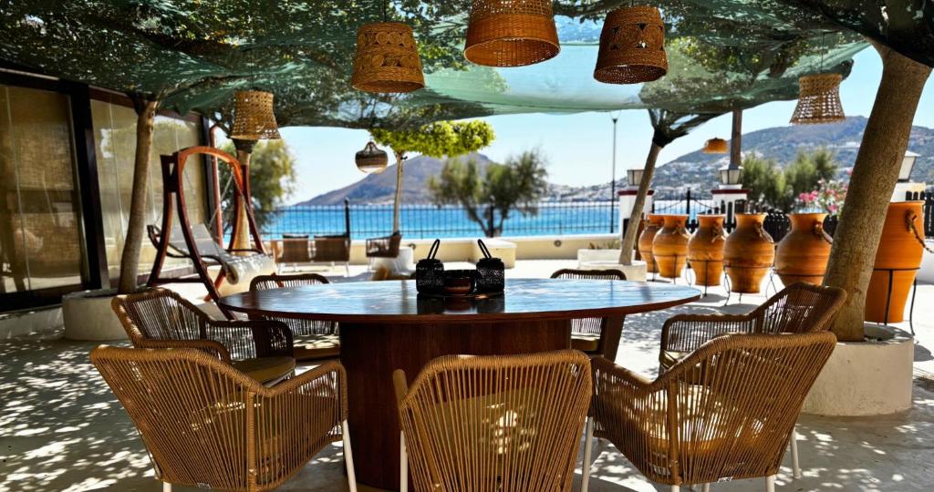 a table and chairs with a view of a pool at Palatino Seafront Residence in Alinda