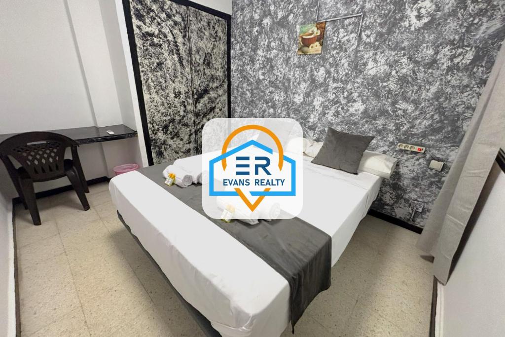 a hotel room with a bed with a sign on it at Evans Realty - Hostal in Fuengirola