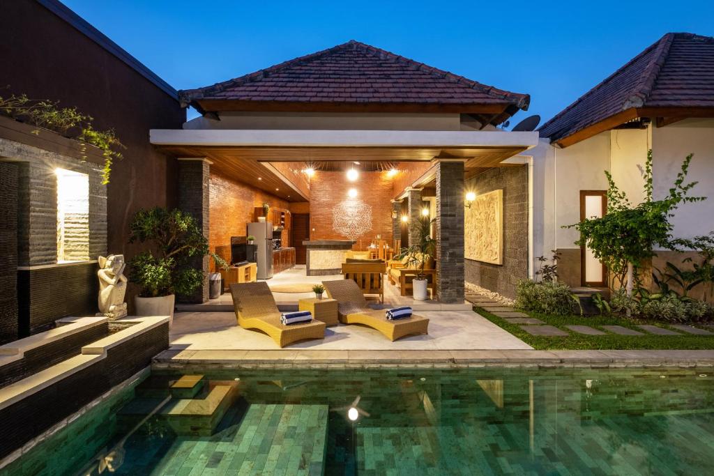 a backyard with a swimming pool and a house at Lapiz Lazuli in Seminyak