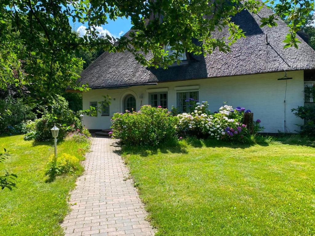 a house with a brick path in front of it at Reethüs am Klintumer Moor in Leck