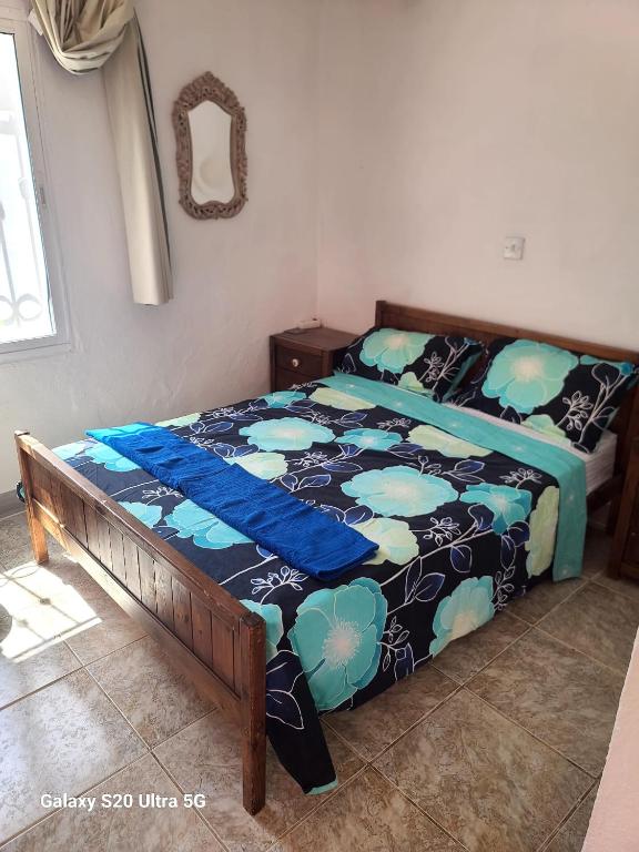 a bedroom with a bed with a blue comforter at La Finca Roja 3 in Coín