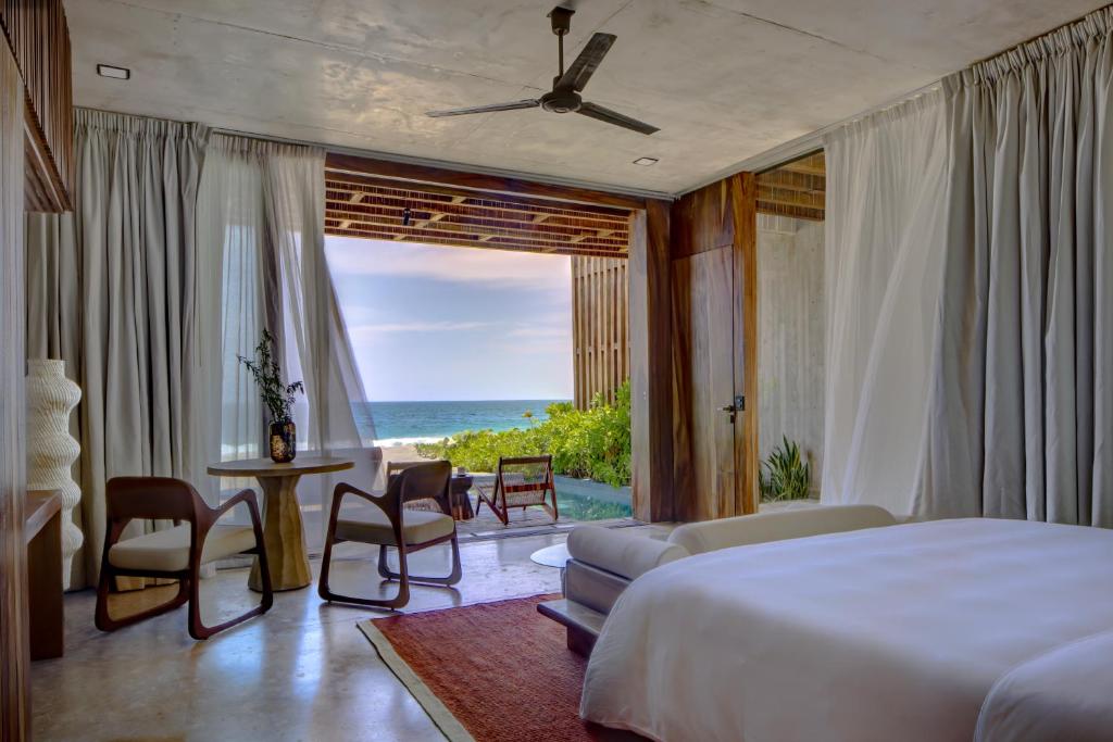 a bedroom with a bed and a view of the ocean at NANANA Hotel de Mar - Solo Adultos in Puerto Escondido
