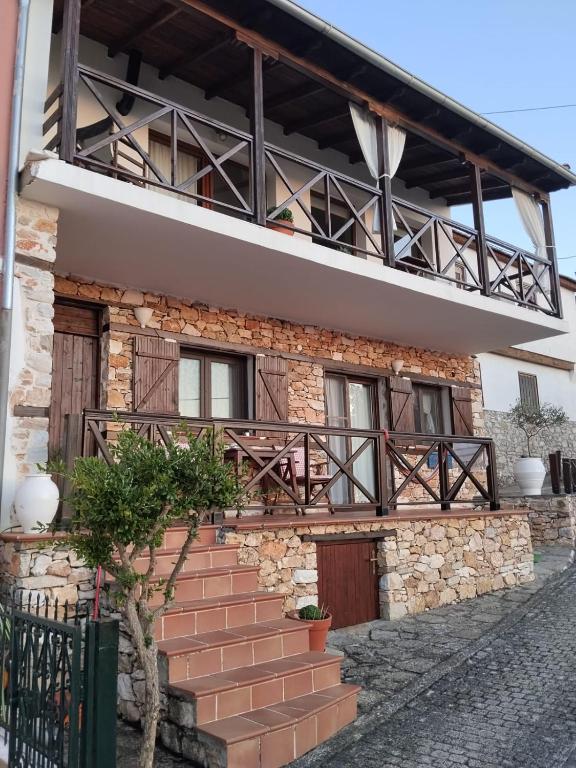 a brick house with a balcony and stairs at Perfect View House in Sotír