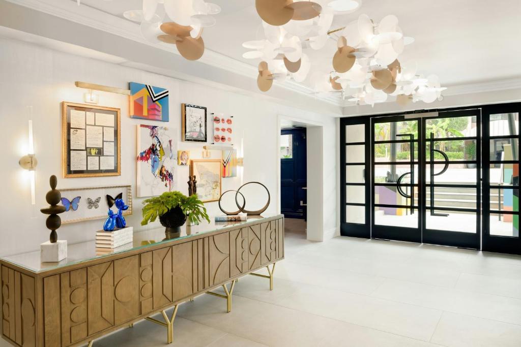 a large living room with a table and a chandelier at Le Parc at Melrose in Los Angeles