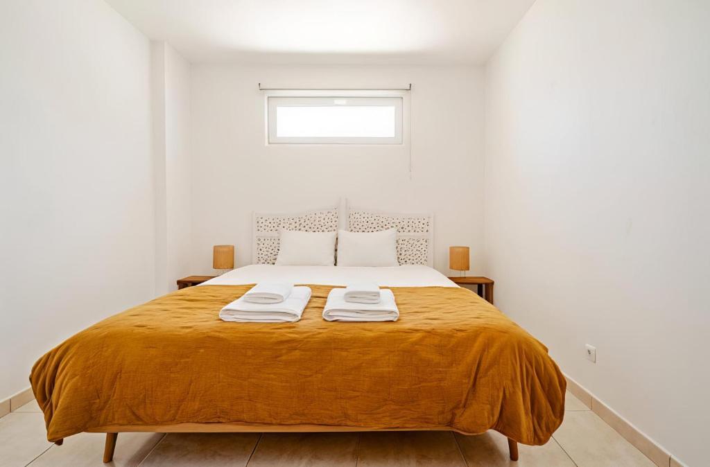a bedroom with a bed with two towels on it at New Horizon Algarve in Almancil