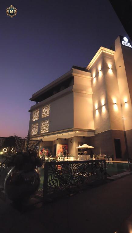 a large building with lights on it at night at Hotel Millennium in Hisār