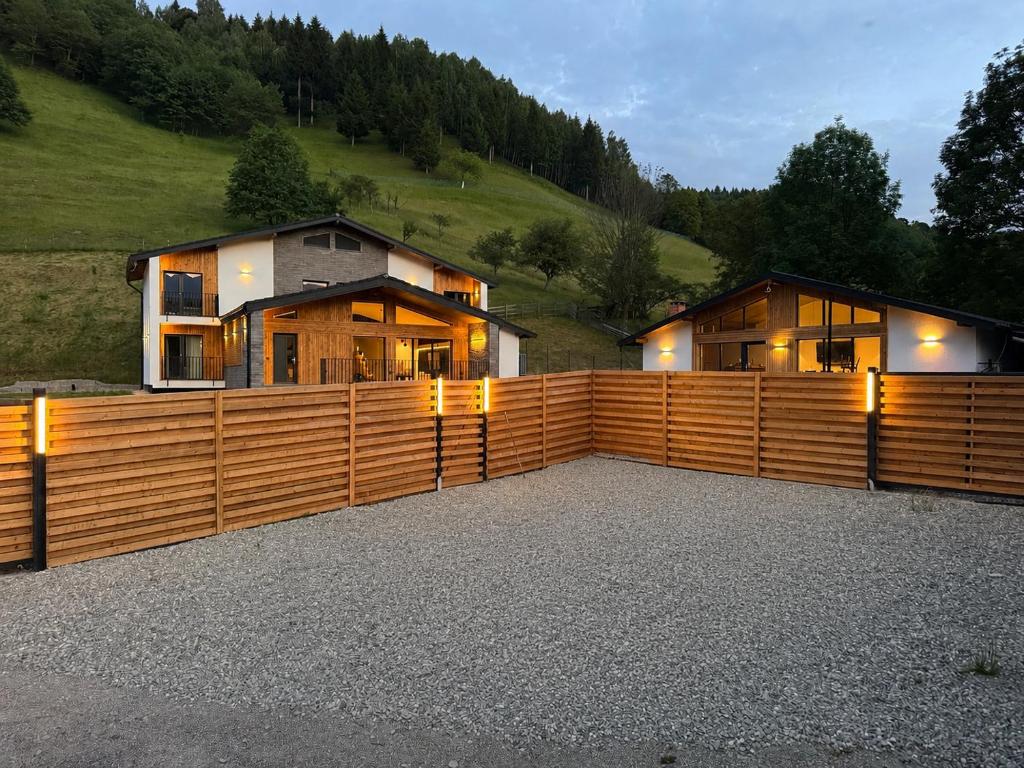 a house with a wooden fence in front of it at Akacia Chalet in Moieciu de Jos