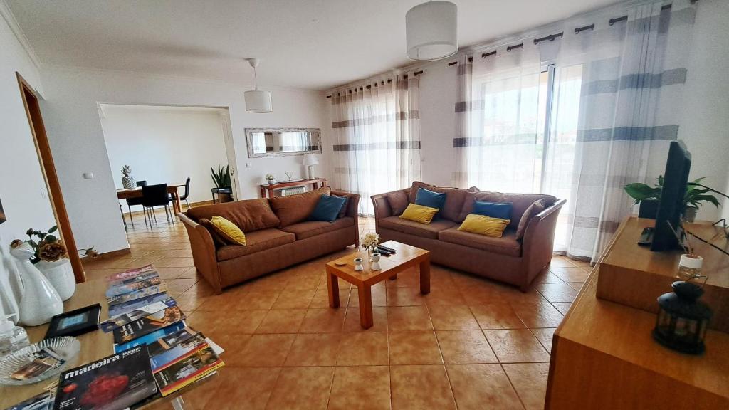 a living room with two couches and a table at Villa Abreu in Ponta do Sol