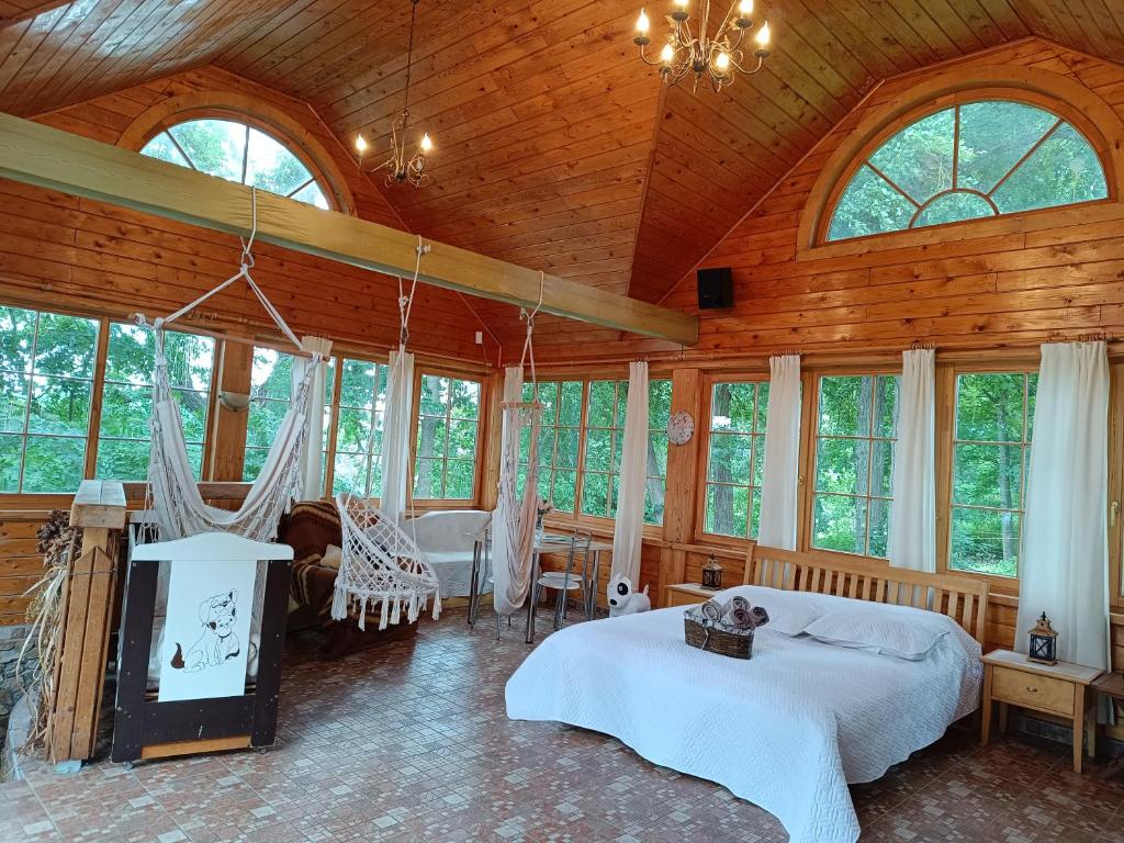 a bedroom with two beds in a room with windows at Jumpravmuižas pirtiņa ar kublu in Mežotne