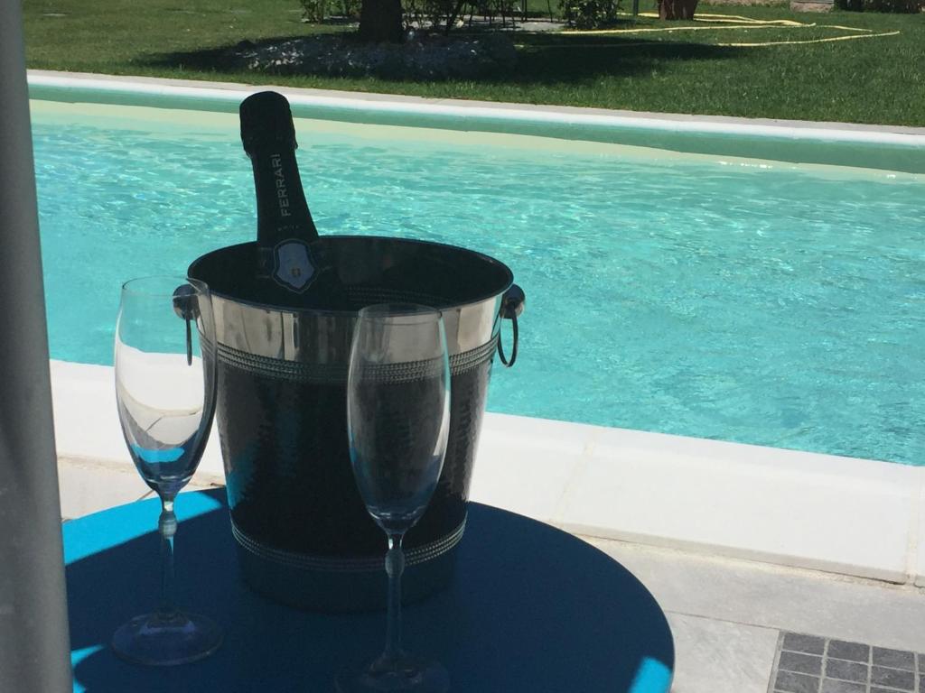 a bottle of champagne in a bucket next to two glasses at FiordiSole Holiday Home in Montopoli in Val dʼArno