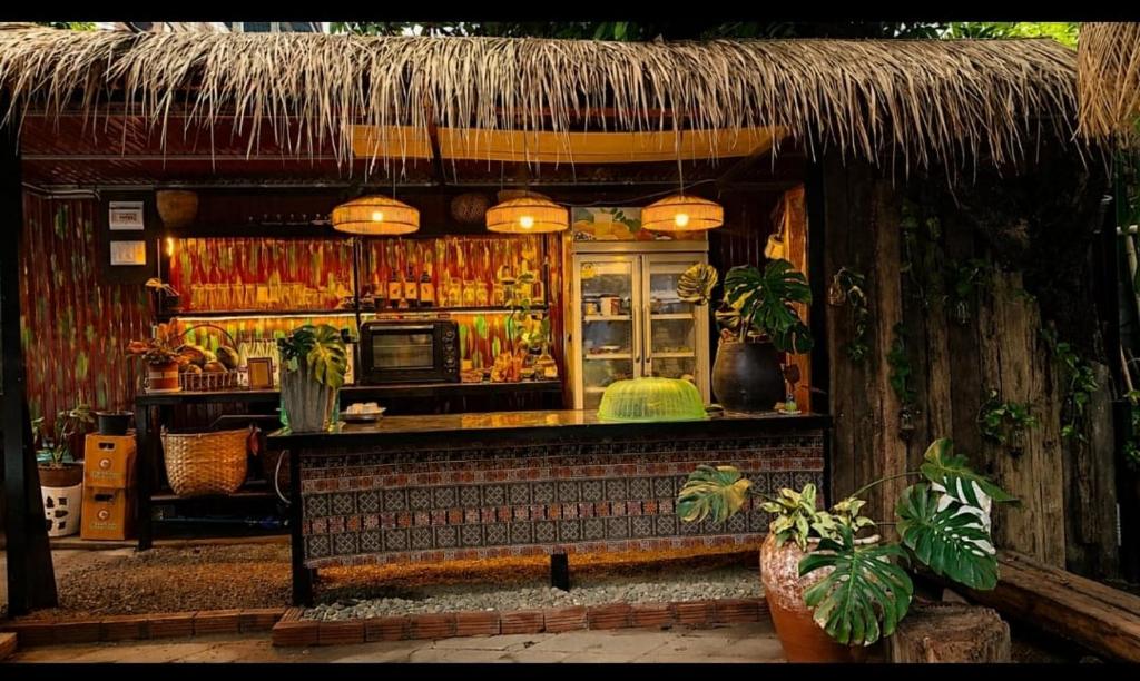 a restaurant with a bar with a thatched roof at MI CASA Luang Prabang in Luang Prabang