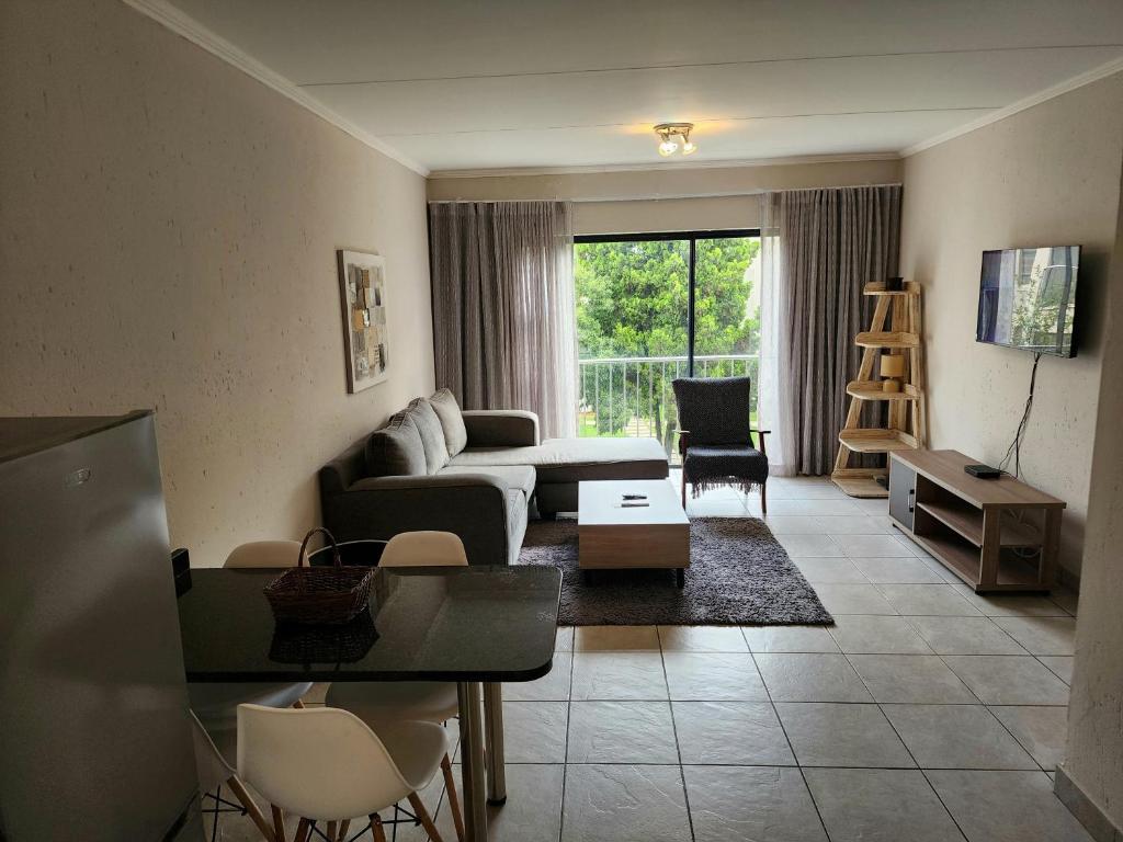 a living room with a couch and a table at Comfort & Style at the Ihita Complex - Beverley, Sandton in Sandton