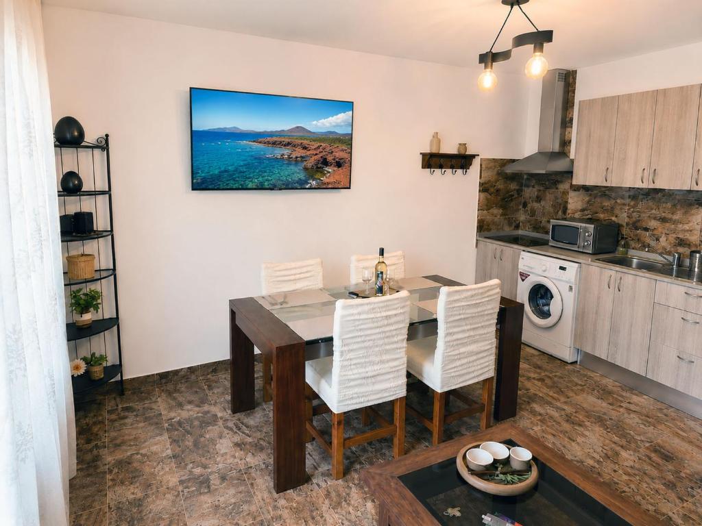 a kitchen and dining room with a table and chairs at Luz del Mar in Órzola