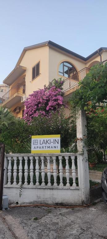 a sign on a fence in front of a building at Laki-in in Meljine