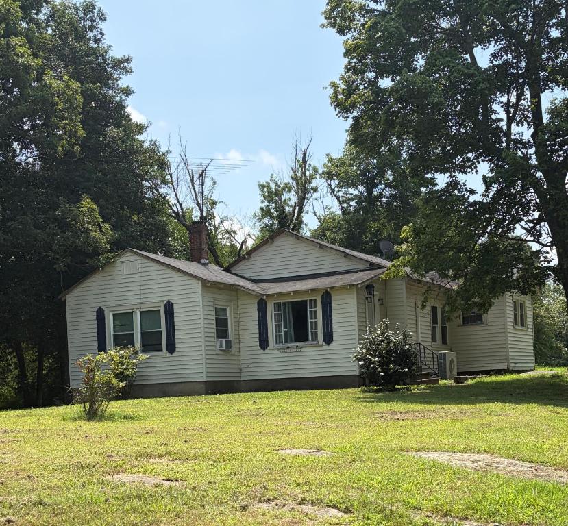 a small white house with a grass yard at Private Cottage in Rural Clemmons in Clemmons