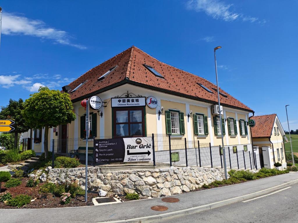 a building with a sign in front of it at Center Grič - sobe, apartma in Sveta Trojica v Slovenskih Goricah