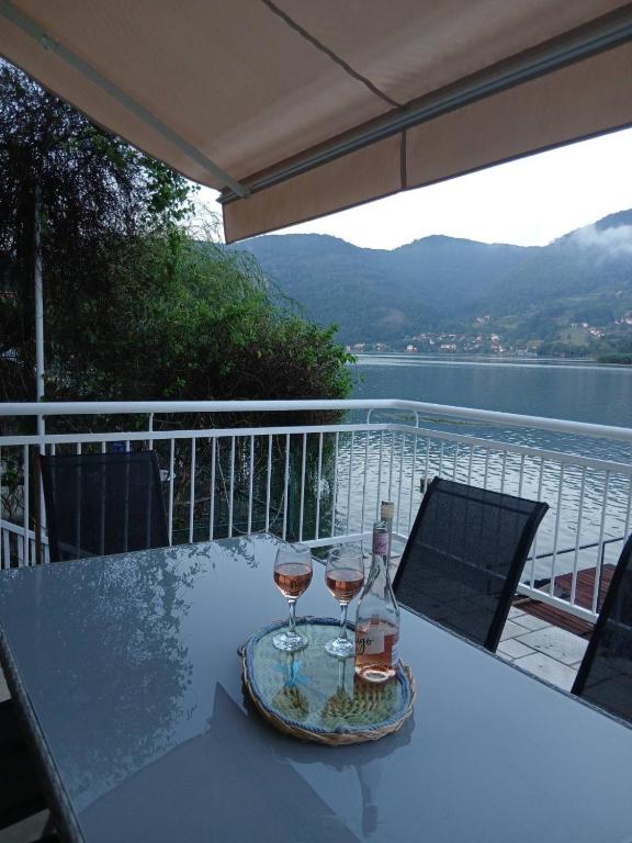 a table with two glasses of wine on a balcony at Drina Lake House in Zvornik