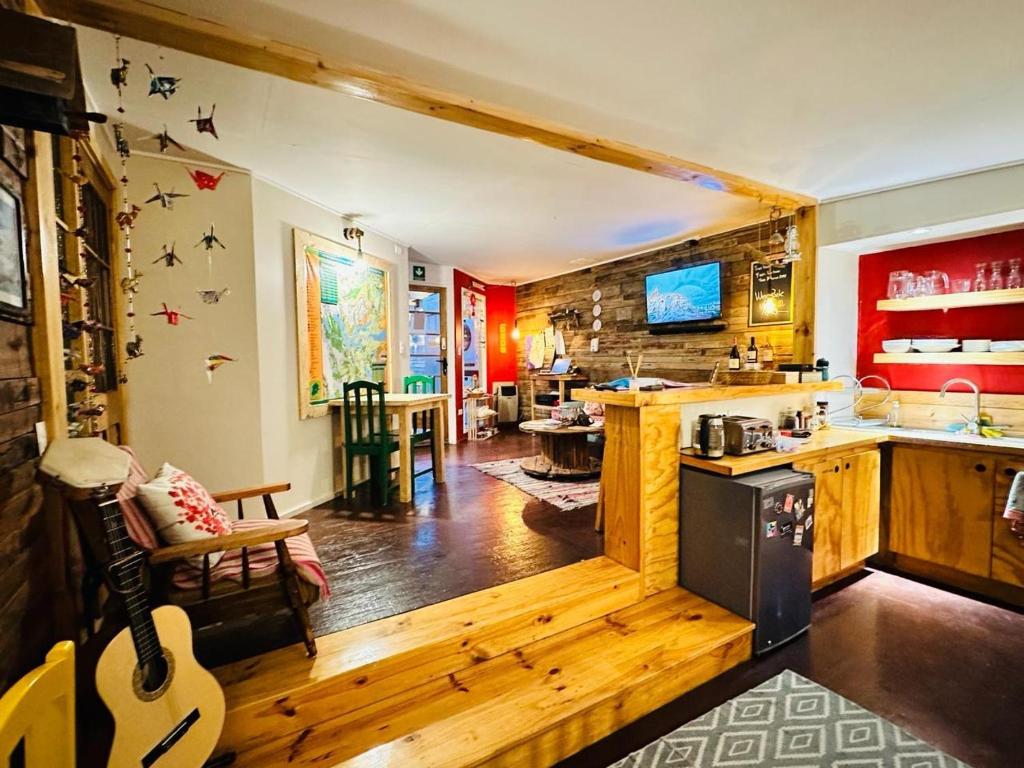 a kitchen and living room with a guitar in a room at Treehouse Patagonia in Puerto Natales