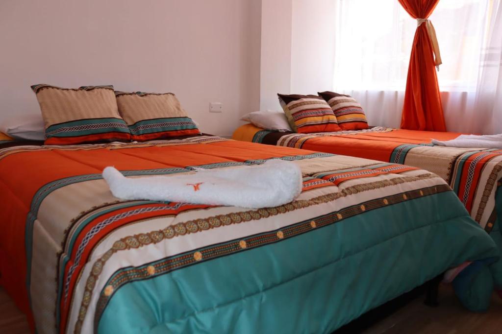 two beds sitting next to each other in a room at Hotel Inkanta in Ipiales