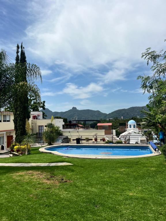a swimming pool in a yard with green grass at Hotel Rinconda del Arcangel in Tepoztlán