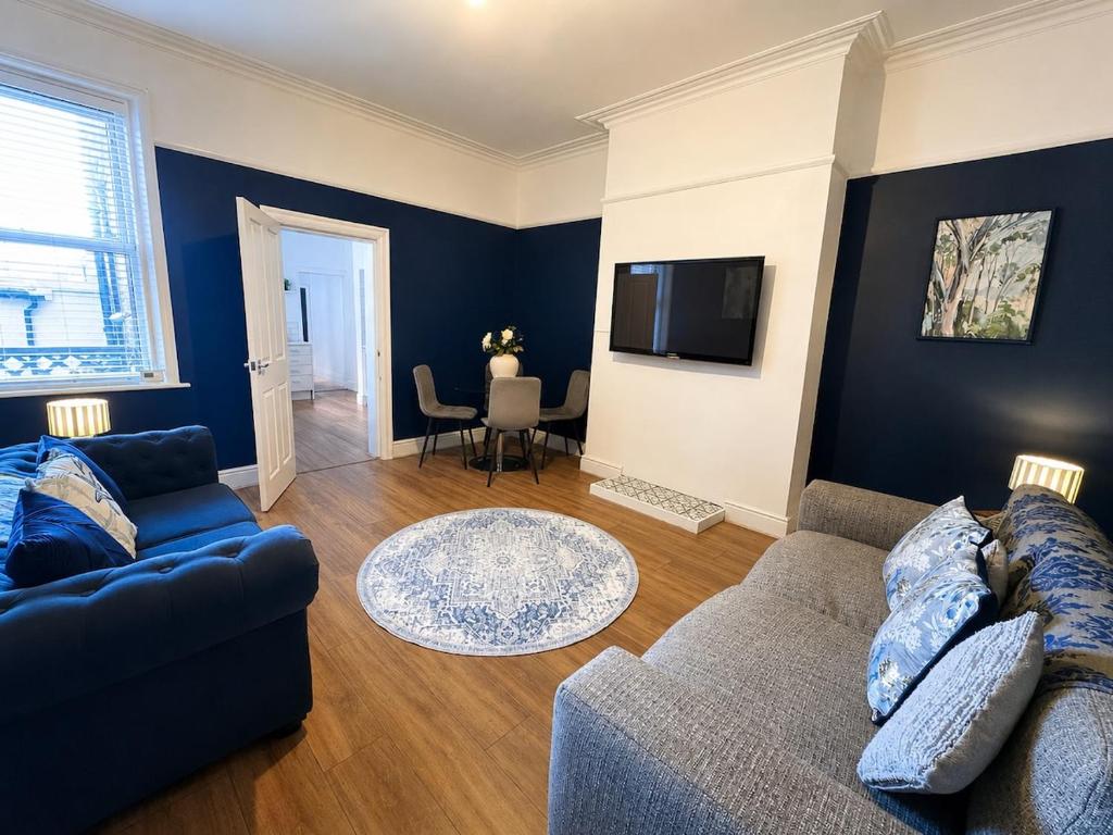 a living room with a couch and a tv at Queenie's Nook in North Shields