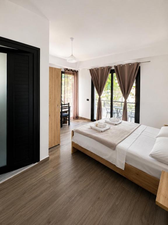 a bedroom with a large bed and a dining room at Lungomare private rooms in Vlorë