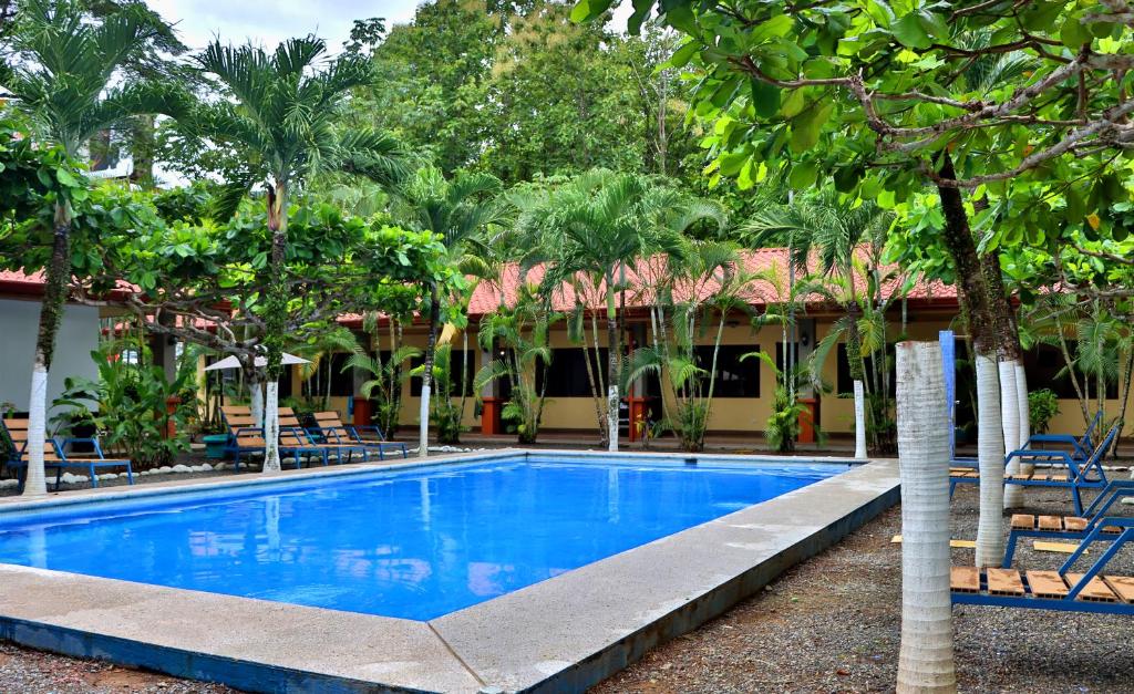 a swimming pool in front of a resort at Hotel D'Lucia - Quebrada Ganado, Jaco, Costa Rica in Puntarenas