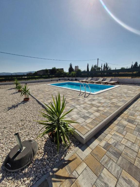 a swimming pool with some plants in a yard at Villa Jopi in Neum