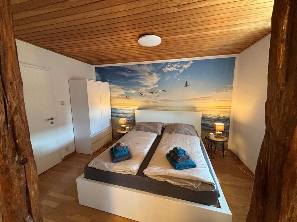 a bedroom with a bed with a painting of the ocean at Fewo kleine Auszeit in Karbach