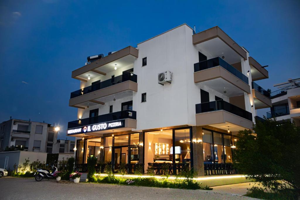 a white building with a sign on it at night at Apartments IL GUSTO in Ulcinj