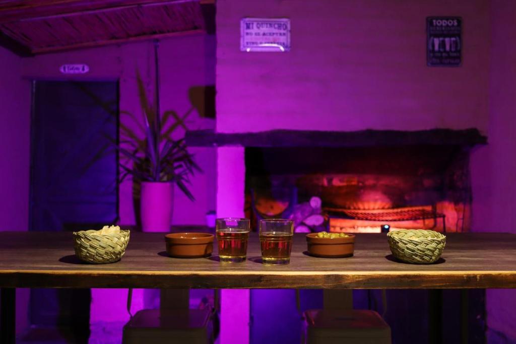 a table with glasses of tea and a fireplace at Marta Maria in El Rodeo
