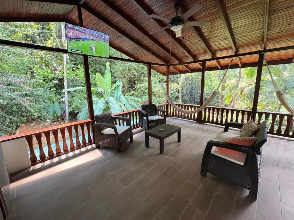 a screened in porch with chairs and a tv at Pacheco Villa in Drake