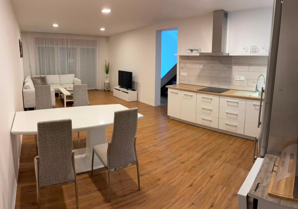 a kitchen and living room with a table and chairs at Apartmán Kutička in Prešov