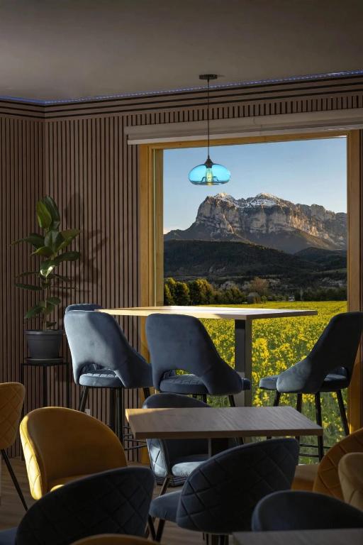 a room with chairs and a table and a view of a mountain at HOTEL Restaurante TurMo in Labuerda